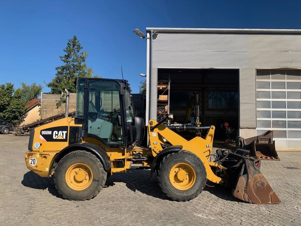 Wheel loader CAT 908M mit Klappschaufe und Palletengabeln